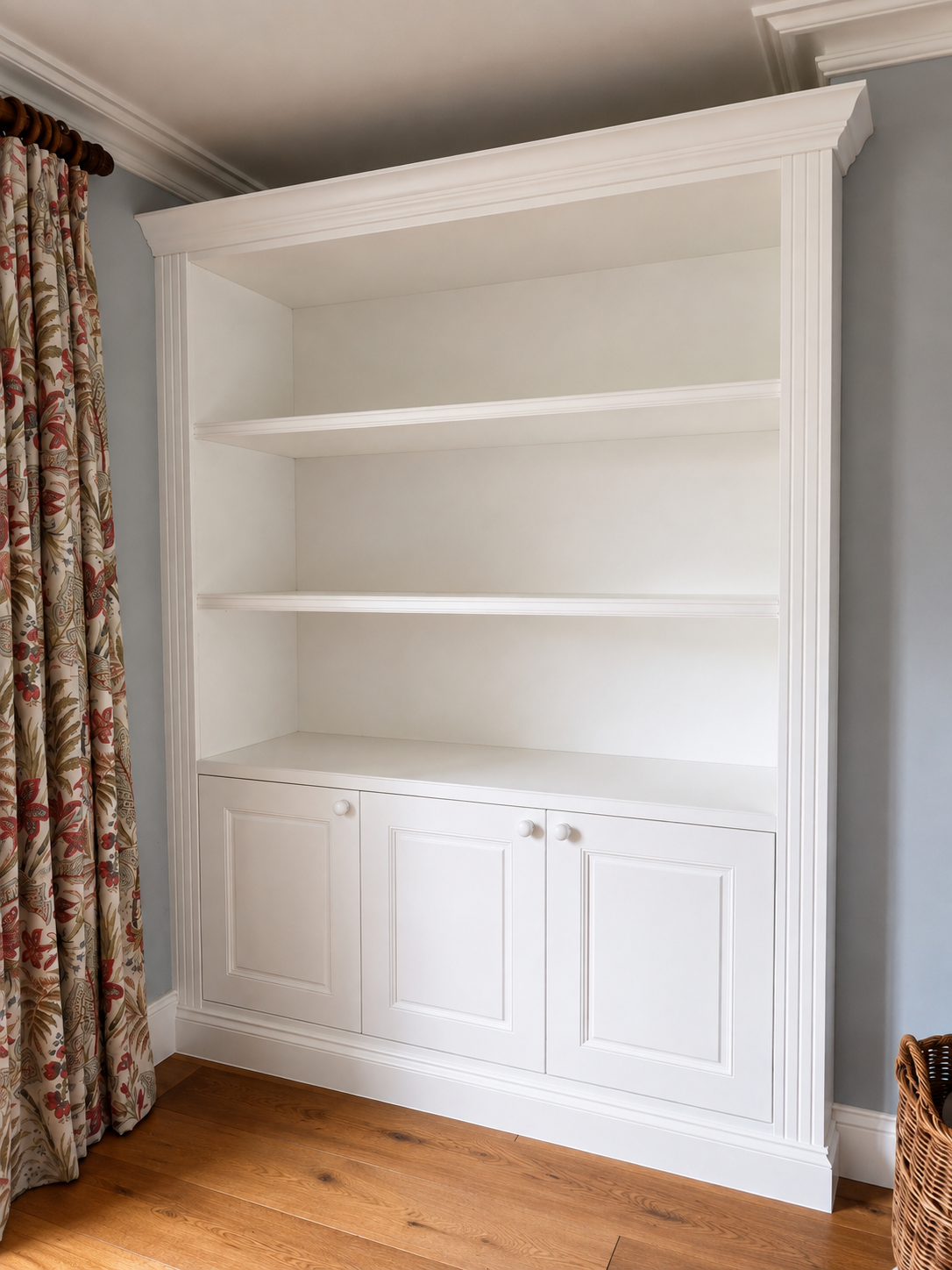 Traditional white built-in alcove shelving unit with display shelves above and Shaker-style cupboards below