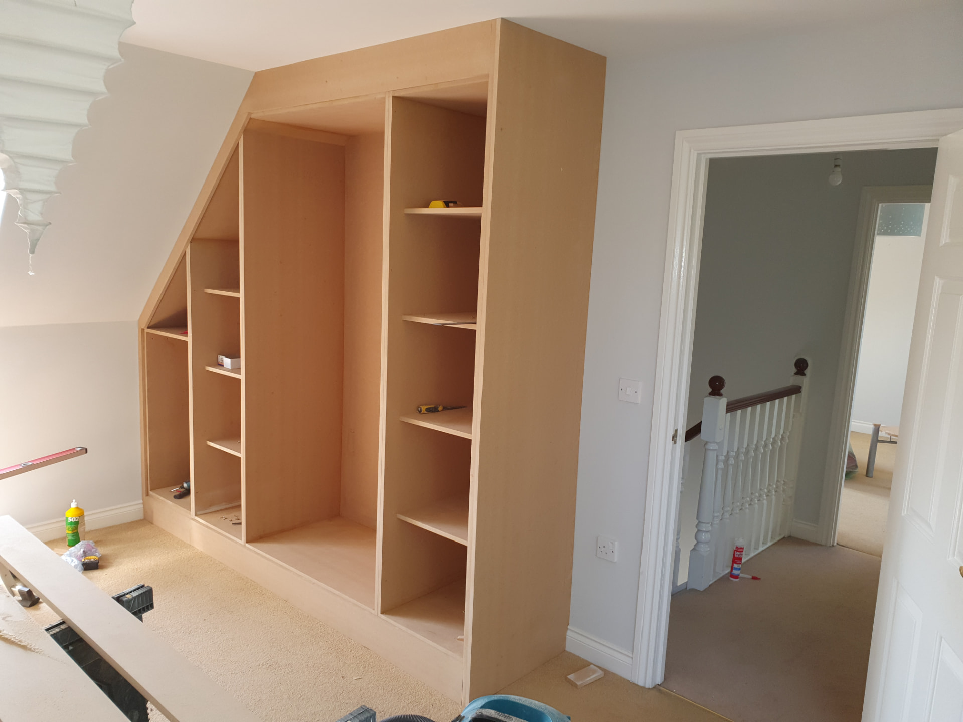 Floor-to-ceiling fitted storage scribed to a sloping attic ceiling