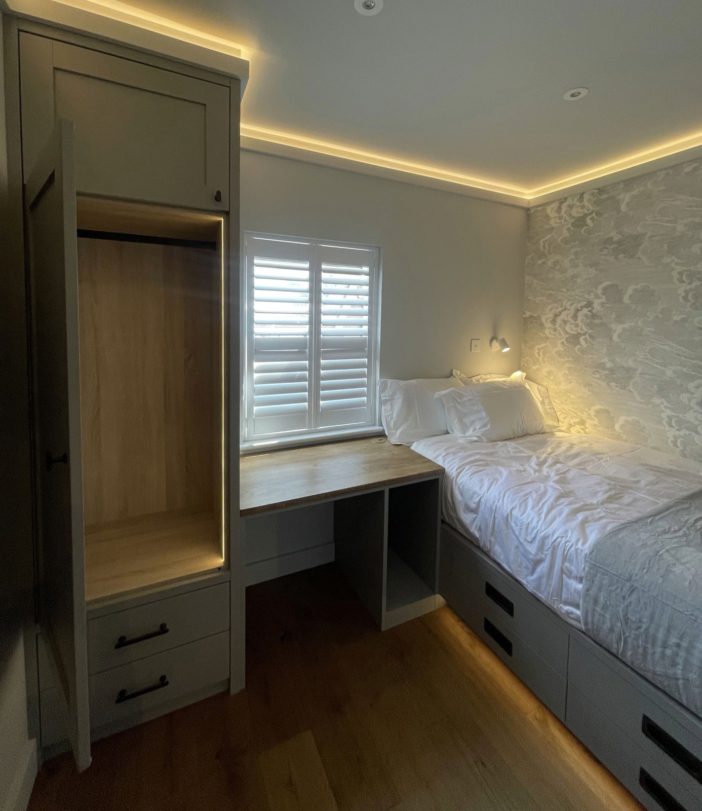 Fitted bedroom with wardrobe, built-in desk, drawers and warm LED lighting