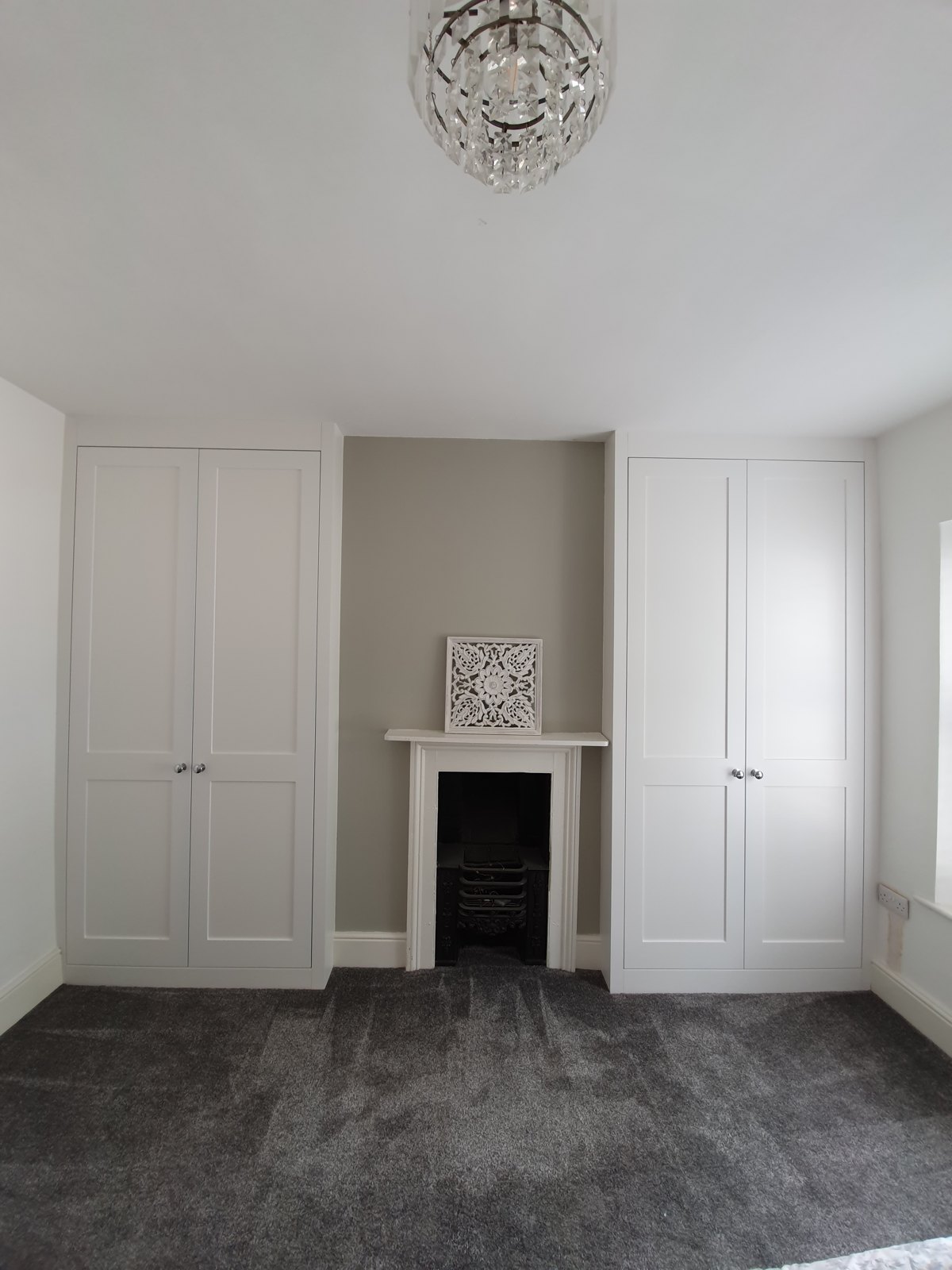 Matching alcove cupboards fitted either side of a fireplace