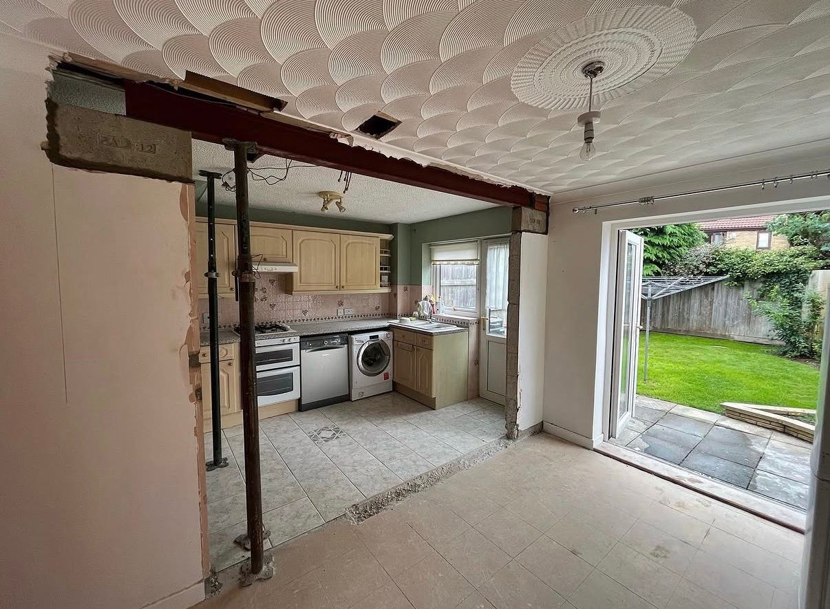 Kitchen mid-renovation with structural steel beam and wall removal